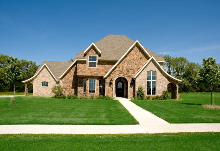 Two-story brick and stone home with a new shingle roof and green lawn