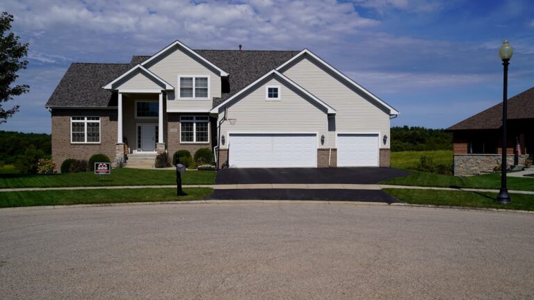 Two-story suburban home with a gray shingle roof and three-car garage