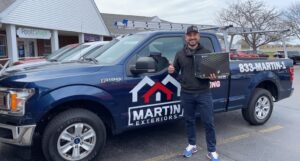 Martin Exteriors team member next to a branded company pickup truck