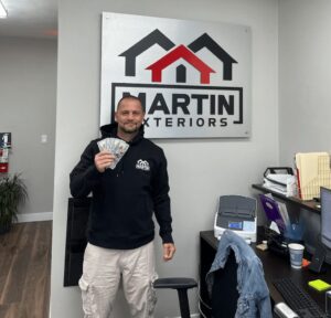 Martin Exteriors team member holding a certificate in the office