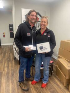Two Martin Exteriors team members holding certificates in the office