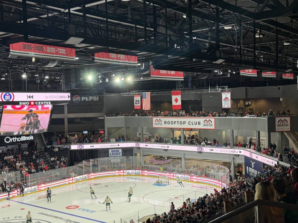IceHogs game at BMO Center with the Martin Exteriors Rooftop Club sign above the rink