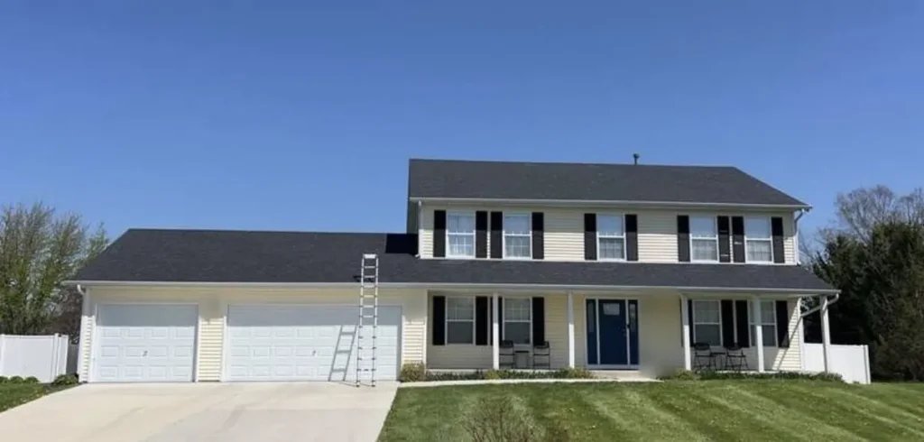 Two story Durand, IL home with pale vinyl siding before new Mastic Ovation siding