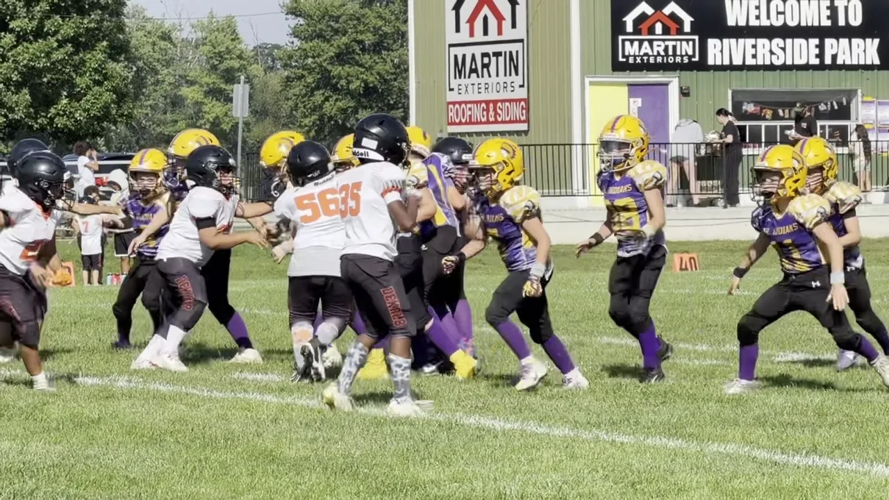Jr. Indians youth football game at Riverside Park with Martin Exteriors sponsor signs