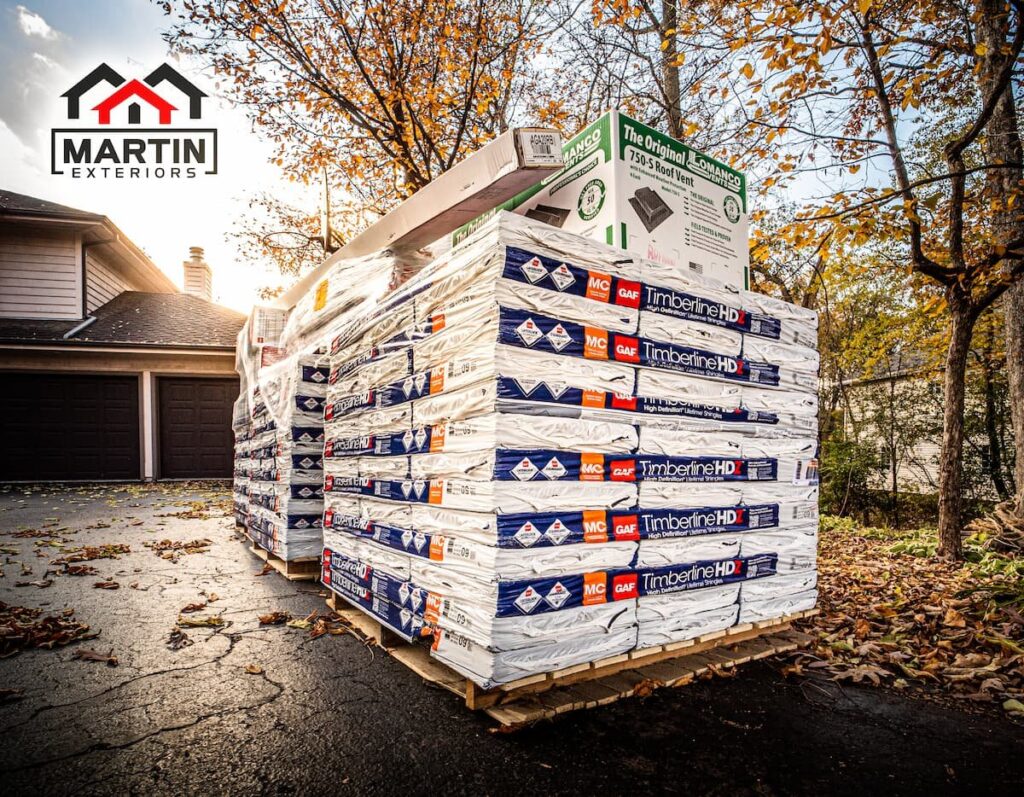 Pallets of GAF Timberline HDZ shingles and roof vents delivered to a driveway for a Martin Exteriors job