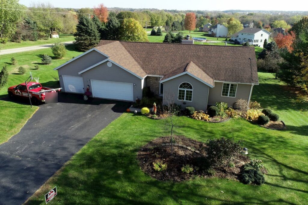 Aerial view of a brown shingle roof by Martin Exteriors on a ranch home with a three-car garage