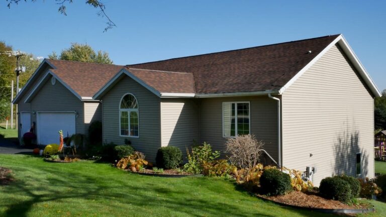Rockford-area new roof by Martin Exteriors on a ranch home with gray siding and flower beds