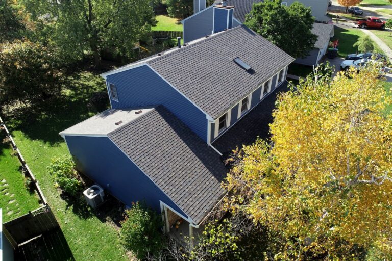 Rockford-area roof replacement by Martin Exteriors, aerial view of a blue two-story home with a new shingle roof