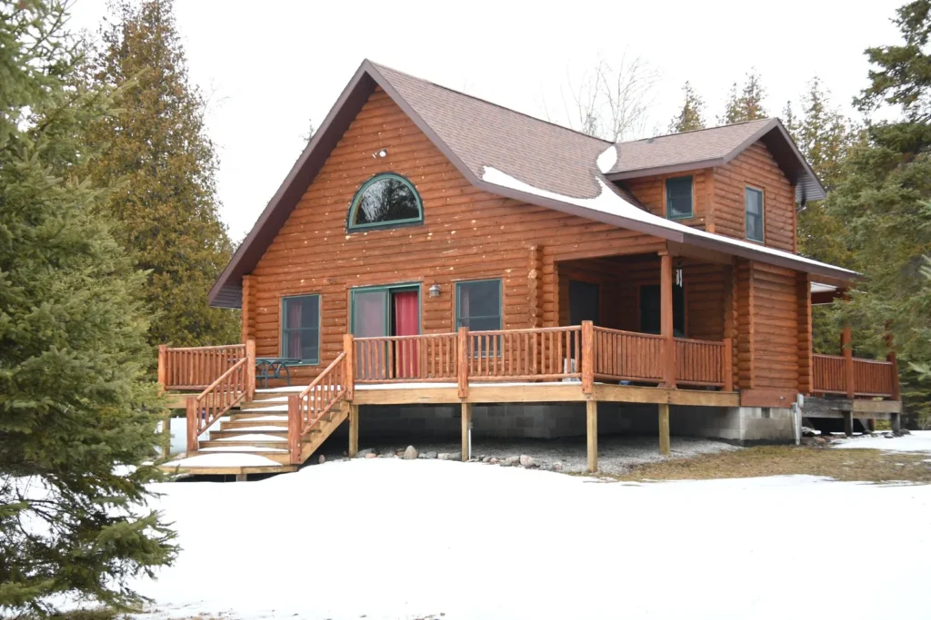 Log sided home in winter with woodpecker holes scattered across the front gable